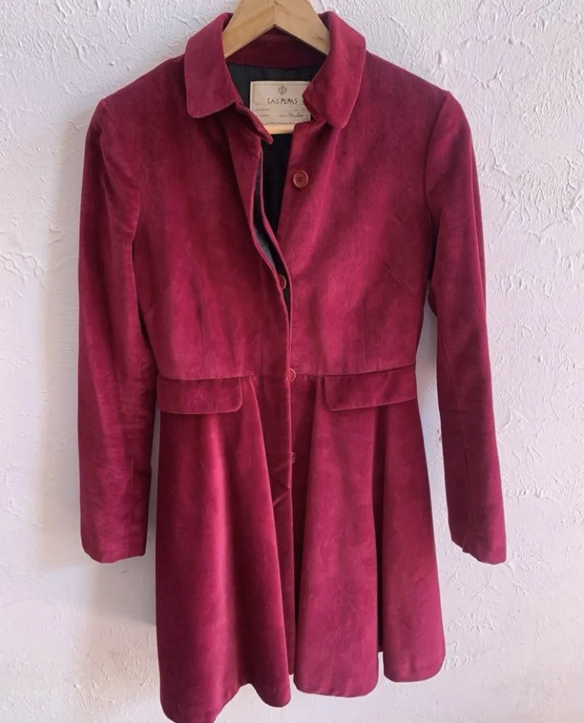 Campera de pana color bordó con cuello solapa y botones al frente. Posee dos bolsillos con tapa a la altura de la cadera. La parte inferior se abre en forma de campana. muy lindo! 