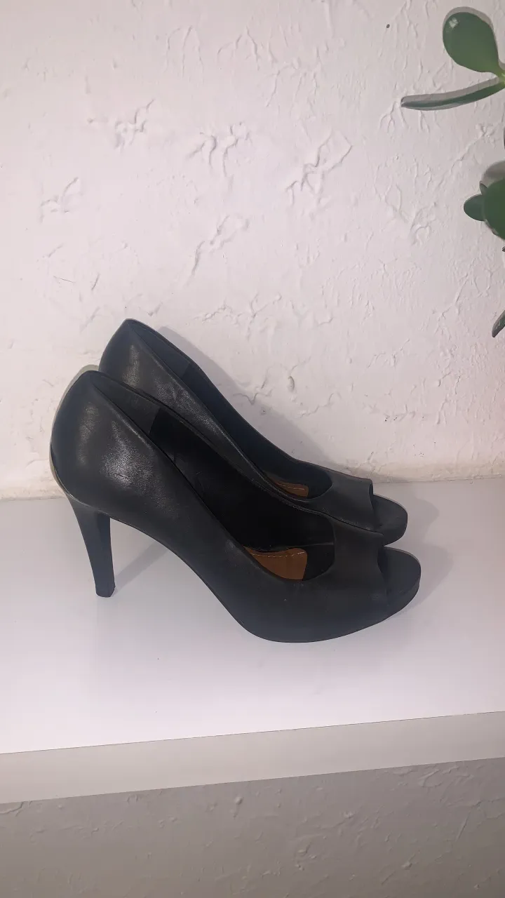 Zapatos negros de taco alto con punta abierta y detalle metálico dorado en el talón. Poco uso 
