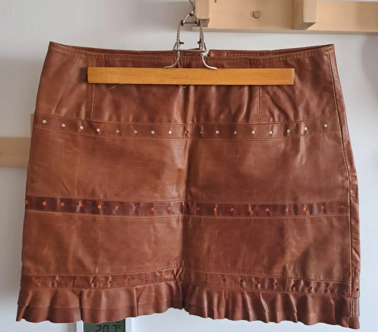 Pollera larga de cuero marrón con detalles de tachas y volados en el borde. Ideal para un look vintage y con estilo.
