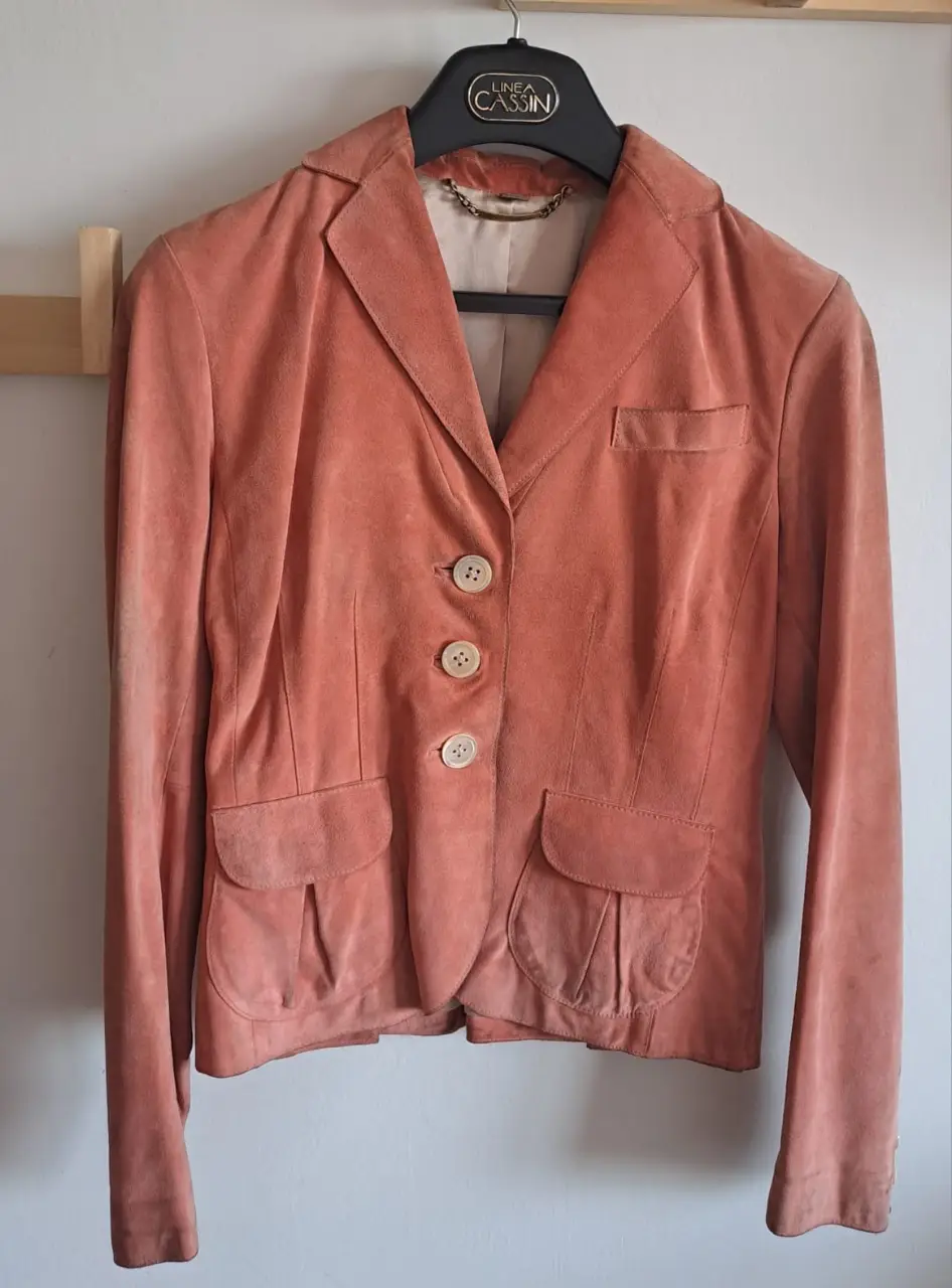 Elegante blazer de gamuza color rosa, con botones y bolsillos delanteros. Ideal para un look sofisticado y femenino.