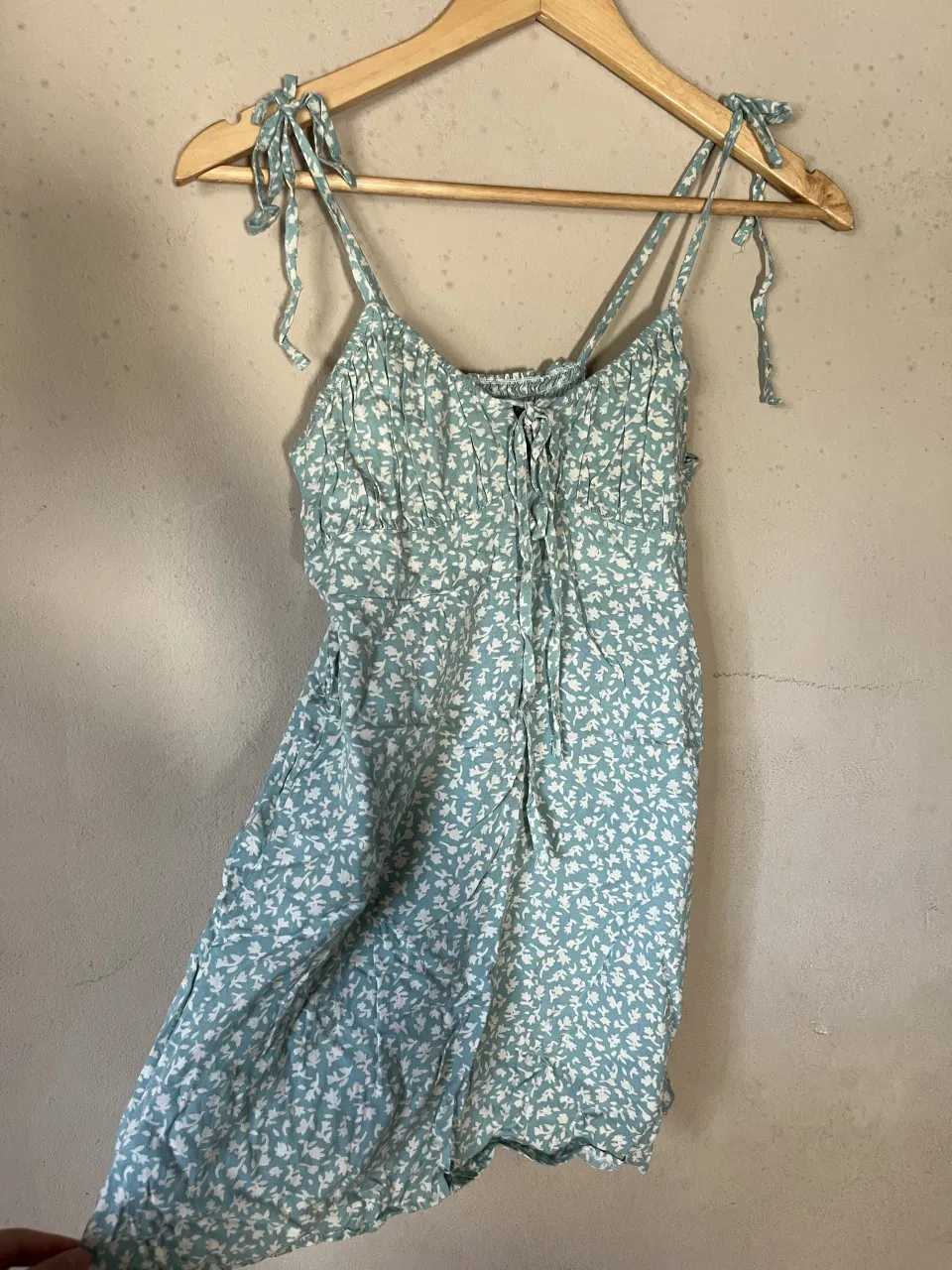 Vestido corto con estampa floral. Breteles finos regulables con nudo. Escote con fruncido y lazo para atar.