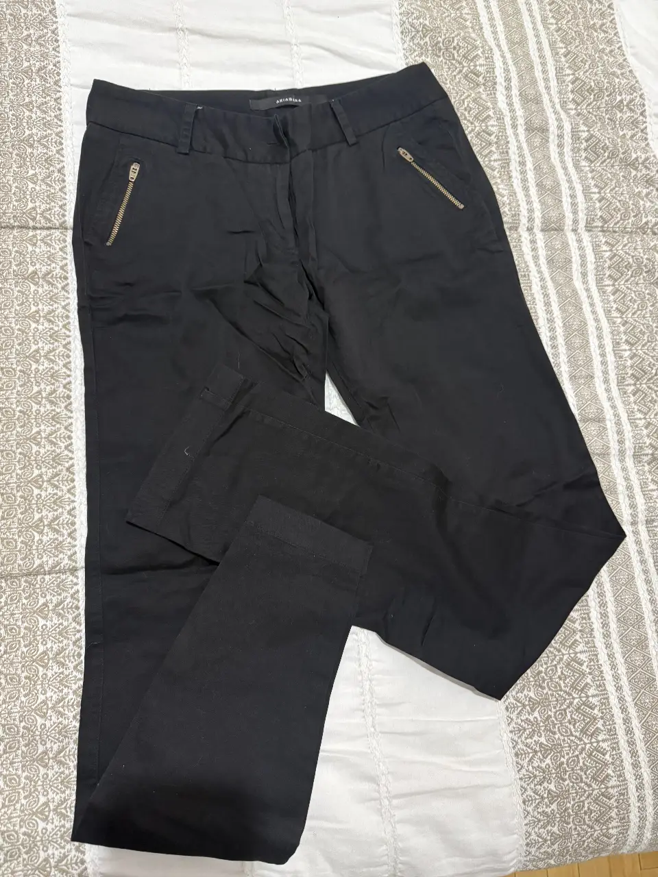 Pantalón sastrero negro de mujer, con bolsillos con cierre en los costados. Ideal para un look elegante y moderno. Tiro bajo. 