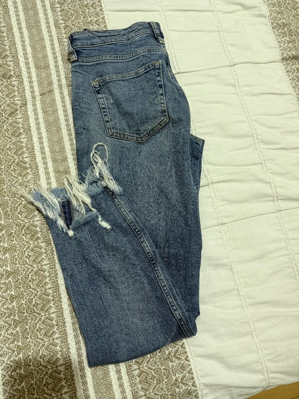 Jeans de mujer, modelo Girlfriend, tiro bajo, con roturas en las rodillas y en el bajo. Talle 27. Marca H&M & Denim. 