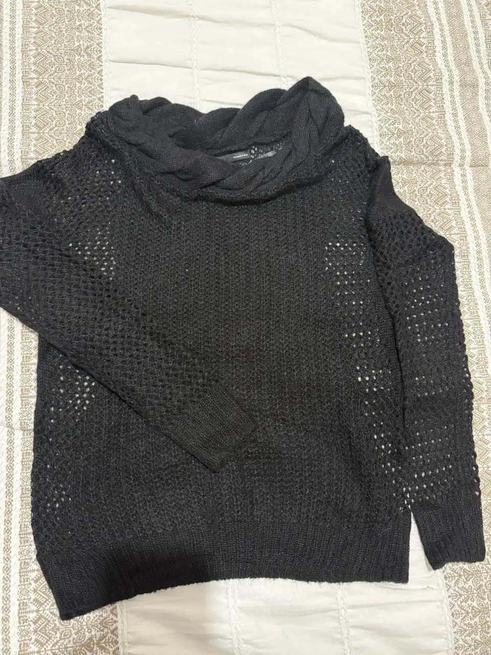 Sweater negro con cuello polera y diseño calado. Ideal para un look casual y abrigado en invierno.