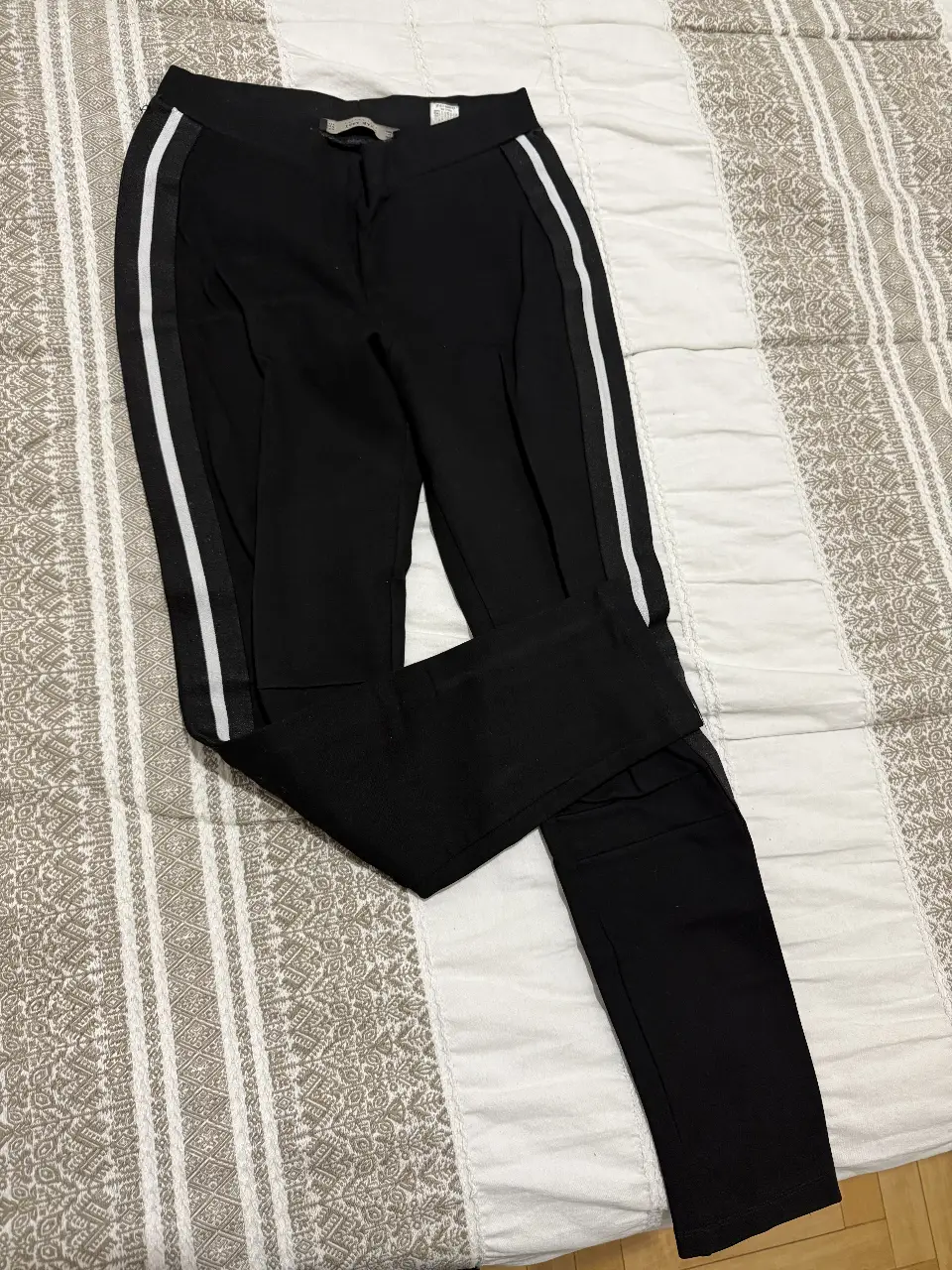 Calza gruesa negra con detalles de rayas blancas en los laterales. Ideal para un look elegante y moderno.