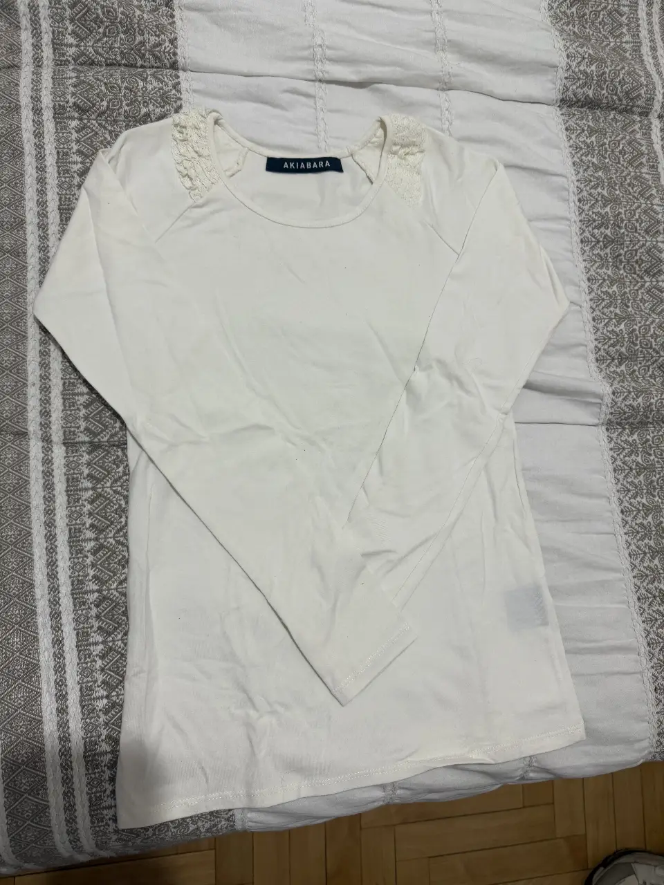 Remera manga larga blanca de mujer, con detalles de encaje en los hombros. Marca Akiabara.