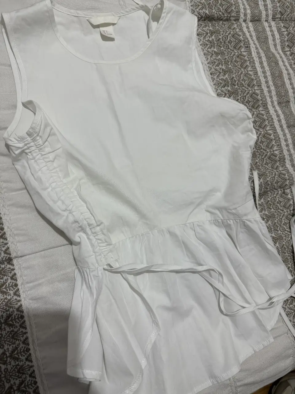 Blusa blanca de H&M, con detalle fruncidos y volados en la parte inferior. Talle EU 34.