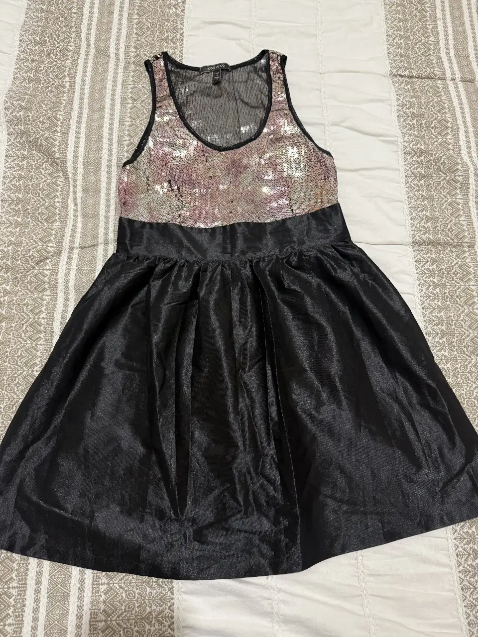 Vestido mini de fiesta con parte superior de lentejuelas doradas  y falda negra. Ideal para eventos especiales y salidas nocturnas.