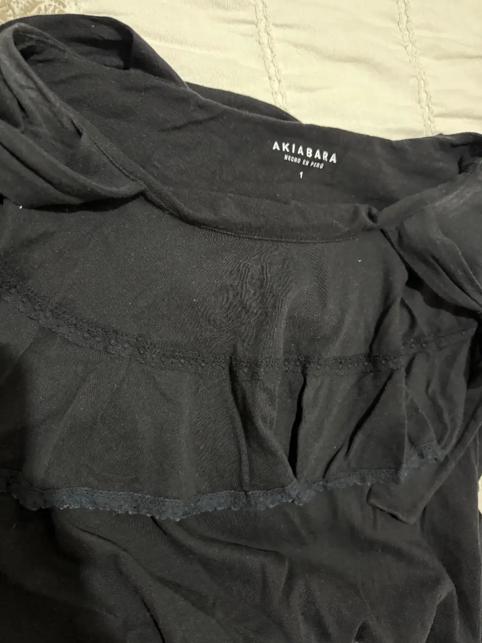 Top negro con detalle de volados y encaje. Ideal para un look casual y femenino.
