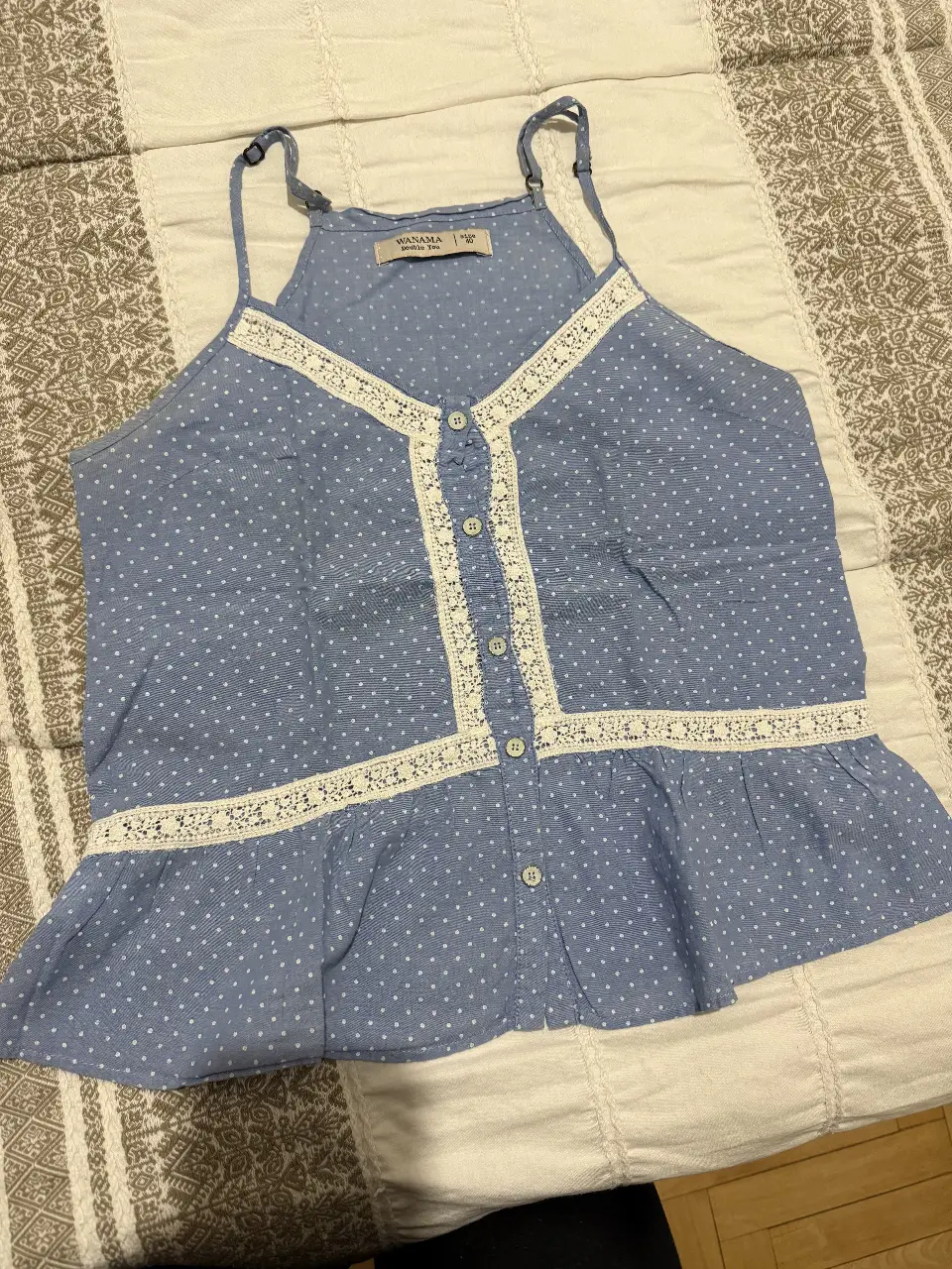 Top de mujer azul con estampado de lunares blancos, detalles de encaje blanco y botones. Ideal para un look casual y fresco.