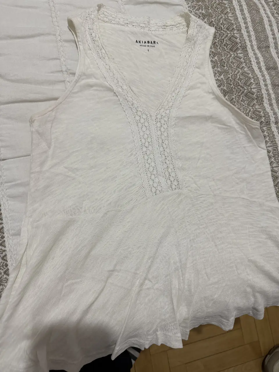 Blusa blanca de Akibara, con detalle de encaje en el escote en V. Ideal para un look fresco y casual.