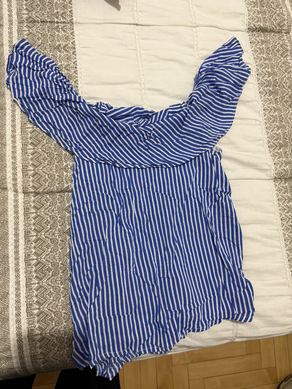 Blusa de mujer a rayas verticales azules y blancas, con detalle de volados en los hombros y tiras para atar. Ideal para un look fresco y casual.