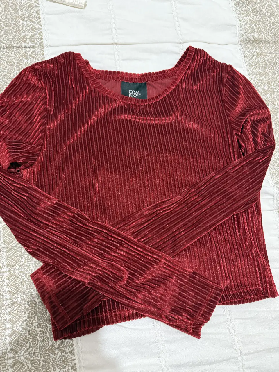 Blusa de terciopelo roja con mangas largas y cuello redondo. Ideal para un look elegante y sofisticado.