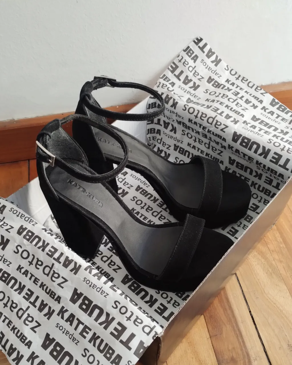 Sandalias de taco alto negras de gamuza, con pulsera en el tobillo y plataforma. Talle 38, marca Kate Kuba. Ideales para una fiesta o salida.