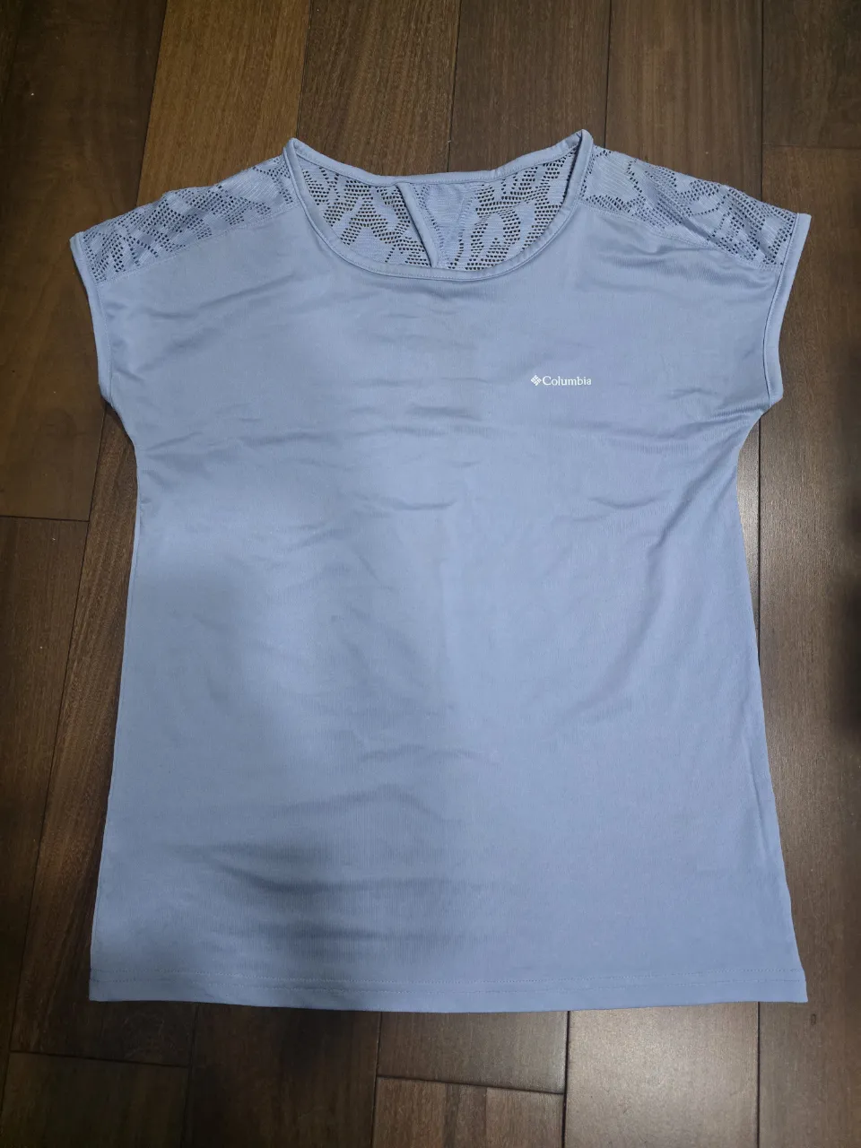 Remera deportiva manga corta, color celeste. Posee detalles de tejido calado en los hombros y espalda superior. Logo de la marca en el frente.