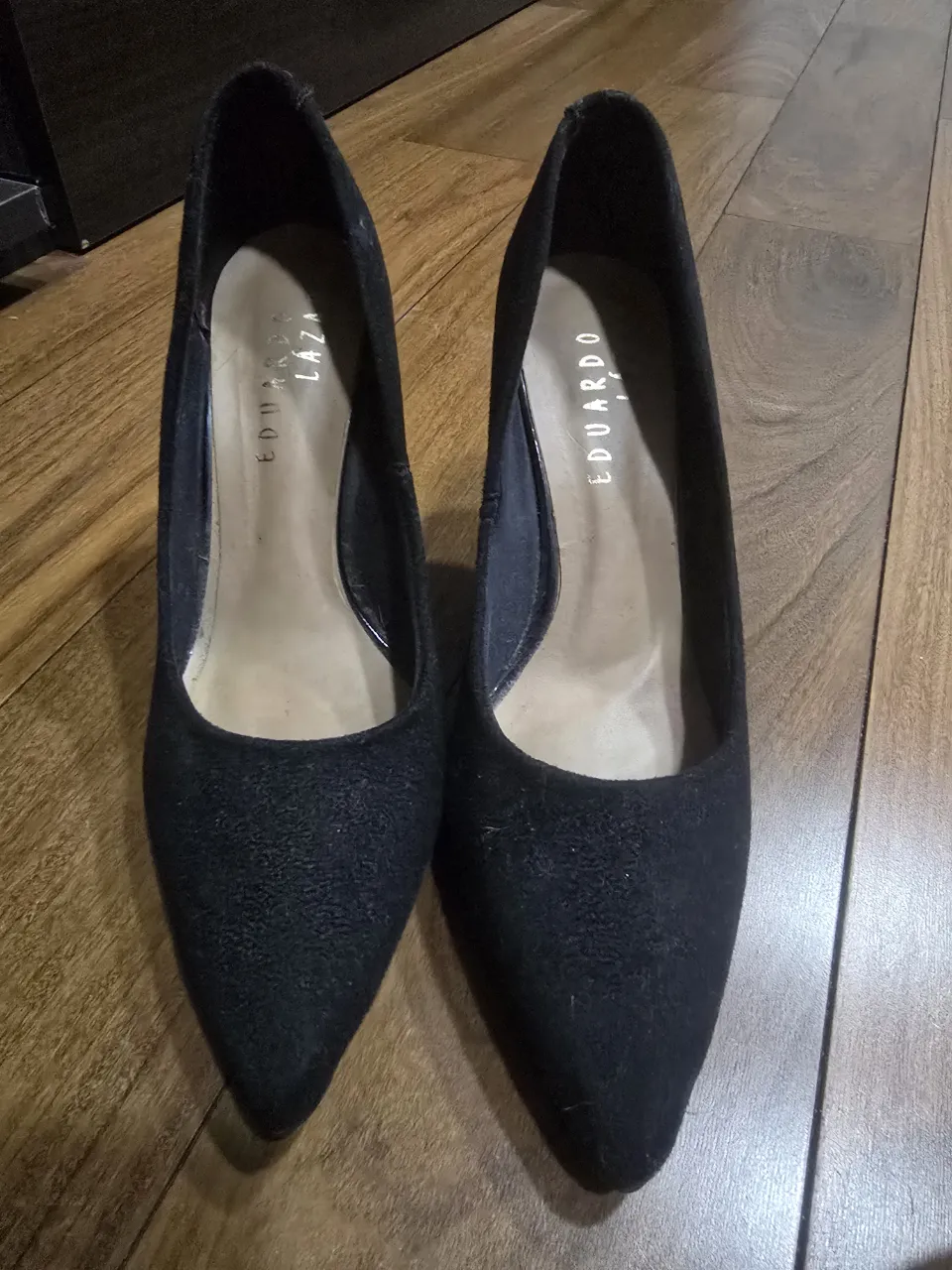 Zapatos de taco alto negros, ideales para eventos formales o para darle un toque elegante a tu outfit. Confeccionados en gamuza, son un clásico que no puede faltar en tu guardarropa.