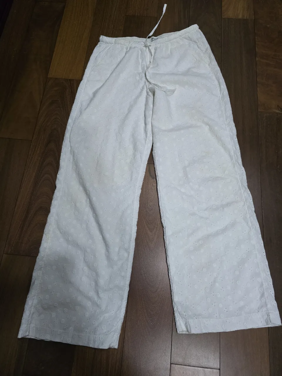 Pantalón blanco de broderie pequeños en toda la tela forrado por dentro. Posee cordón para ajustar en la cintura y bolsillos laterales. puede ser para un S