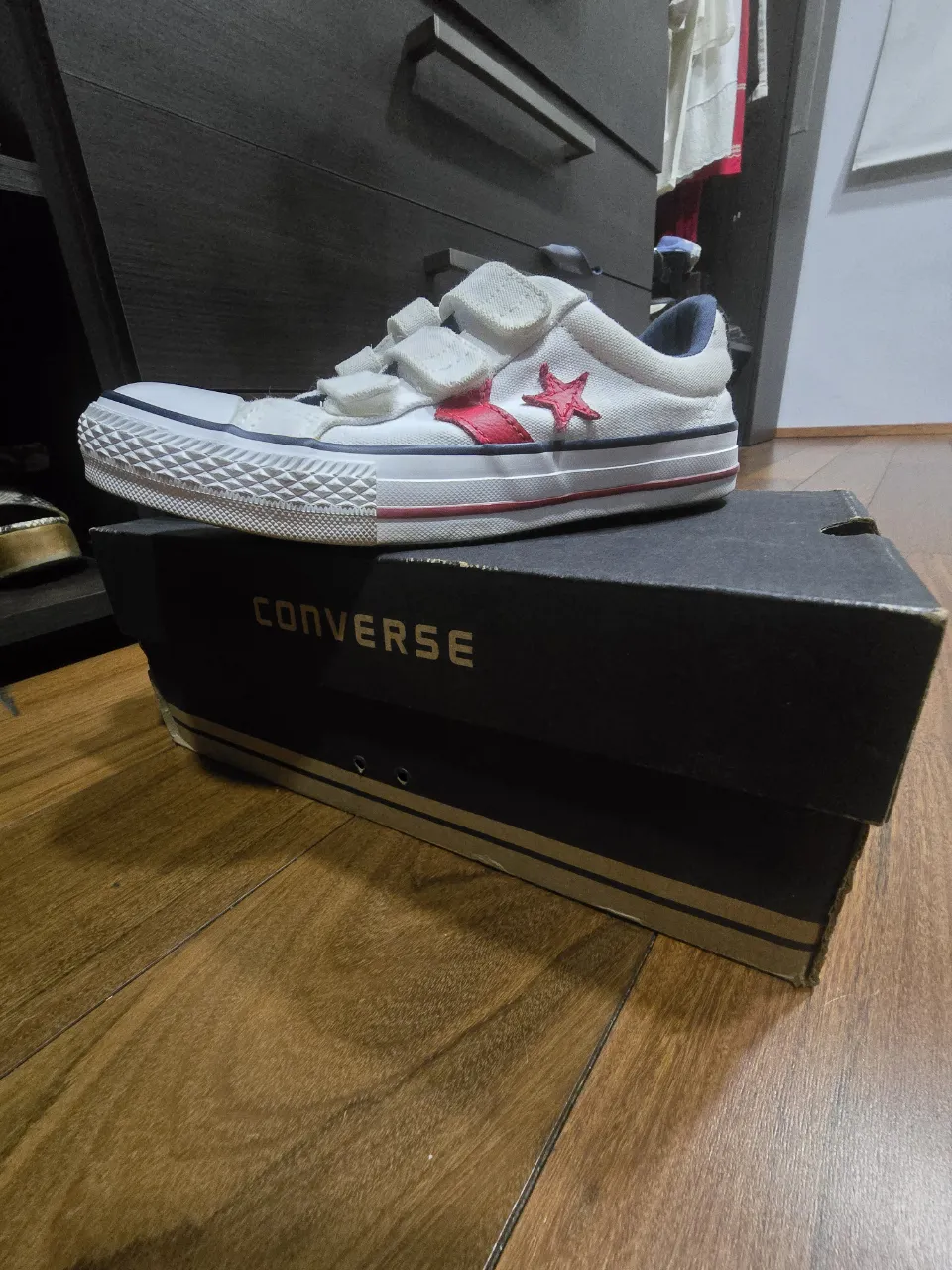 Zapatillas Converse blancas con detalles en rojo y azul. Tienen abrojo para un calce fácil y cómodo. Ideales para el día a día o para un look casual y deportivo.