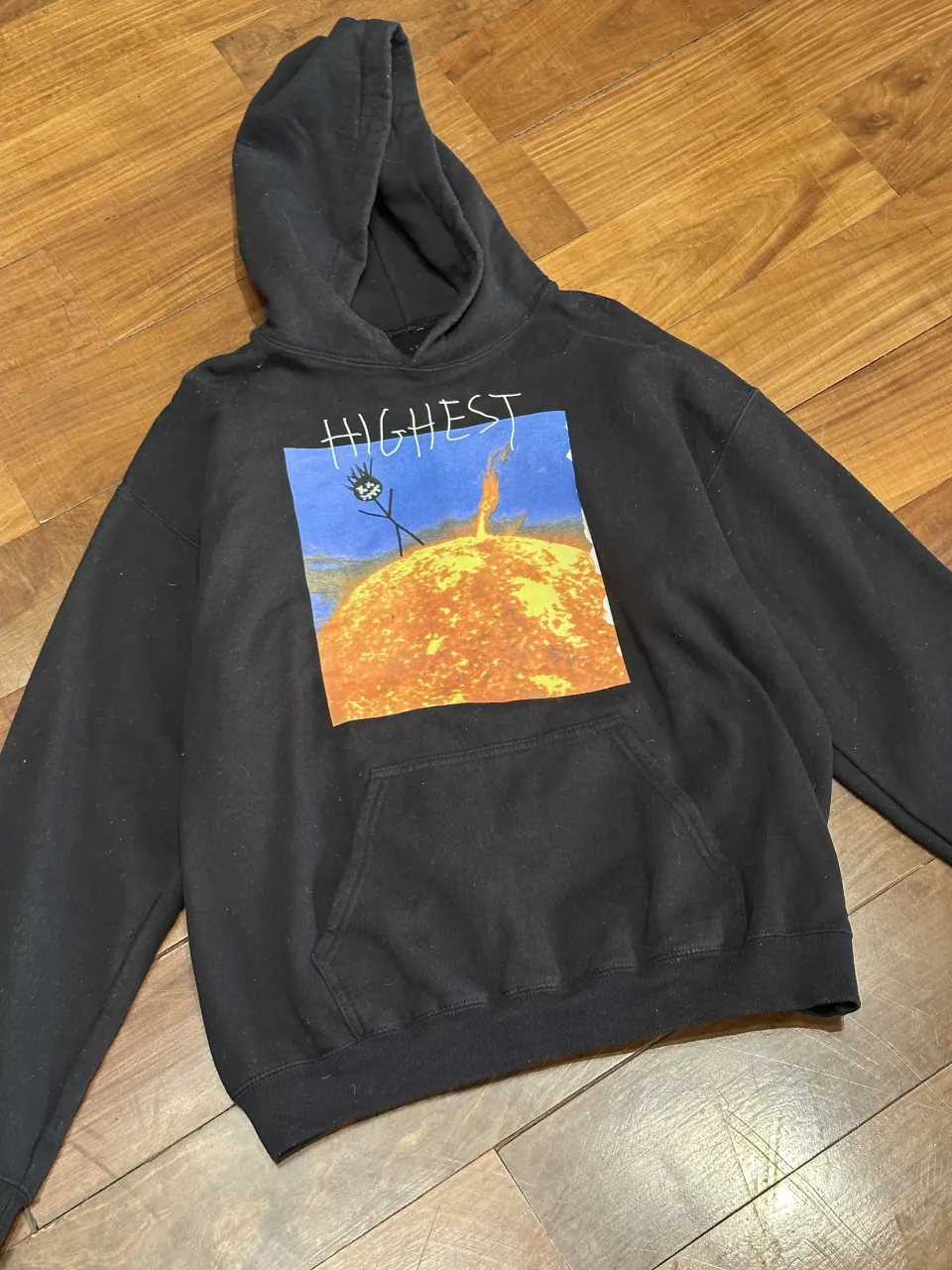 Buzo negro con capucha y estampa "Highest" en el frente. En la espalda tiene la frase "TURN IT UP TILL THEY CANT HEAR" y un diseño de cactus.