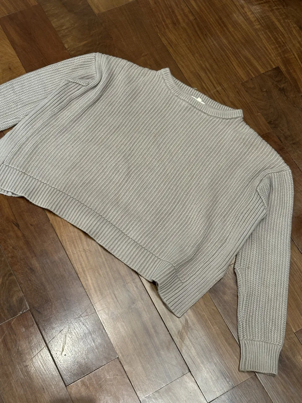 Sweater de tejido de punto color crudo con cuello redondo y mangas largas. Posee un corte a la cintura y detalles de costura en los laterales.