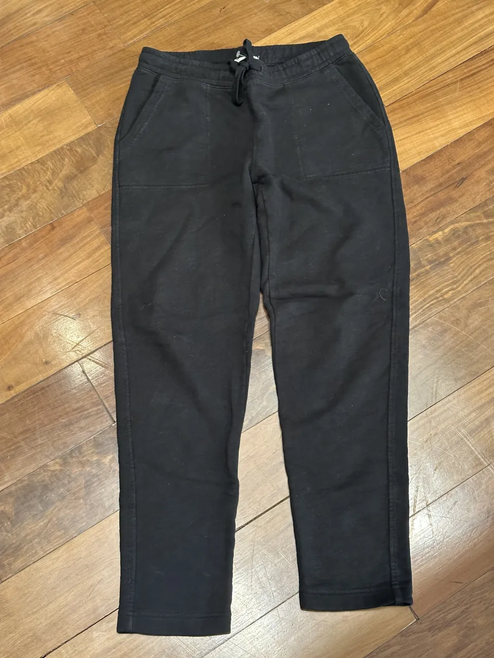 Pantalón de algodón negro con cordón en la cintura y bolsillos delanteros.