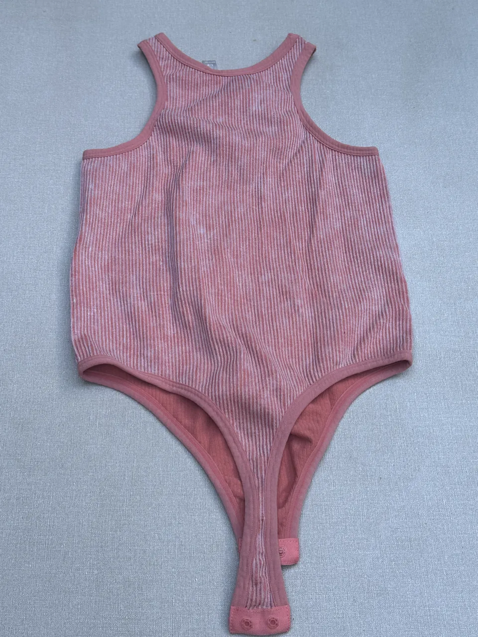 Body de morley con rayas verticales en tonos rosas y blancos. Escote redondo y breteles anchos. Ideal para un look casual y cómodo.