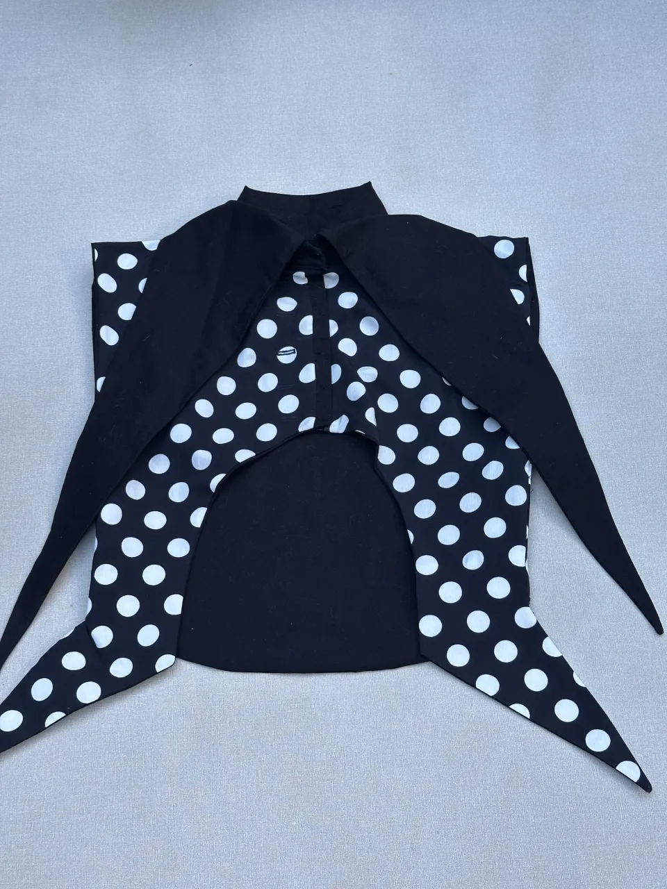 Camisa de seda negra con lunares blancos, cuello mao y lazos largos. Un diseño audaz y chic, perfecto para destacar en cualquier ocasión.