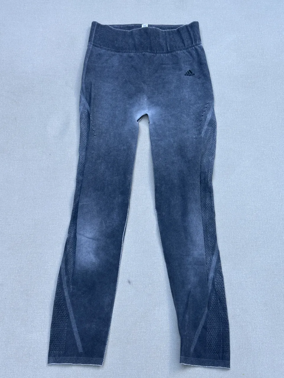 Calzas deportivas Adidas, tiro alto, con detalles de tejido y recortes. Ideales para entrenar o para un look casual y cómodo.