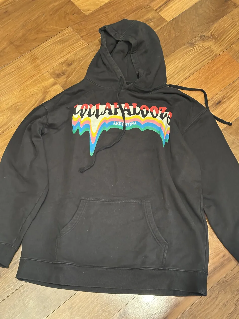 Buzo negro con capucha y estampa multicolor "COLLAPALOOZA ARGENTINA" en el frente. Posee bolsillo canguro.