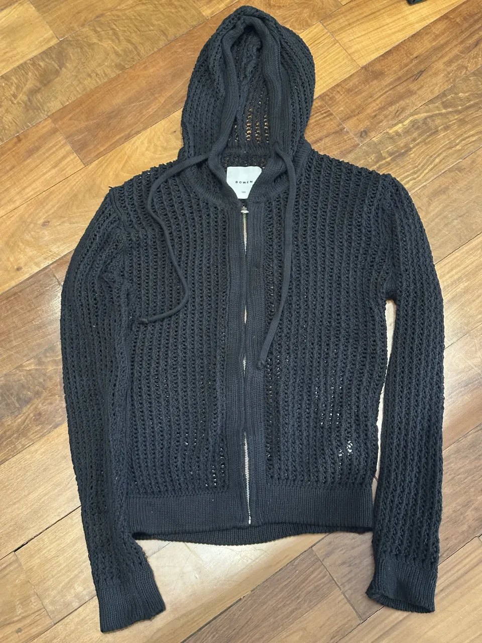 Buzo tejido con capucha y cierre completo. Posee cordones para ajustar la capucha. Es talle 1 pero es bastante grande. 