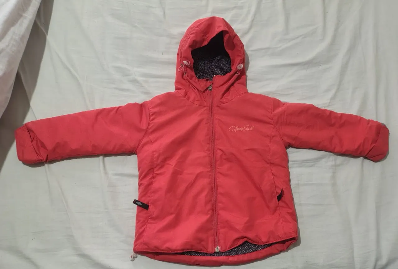 Campera color coral con capucha y cierre al frente. Bolsillos a los costados. 