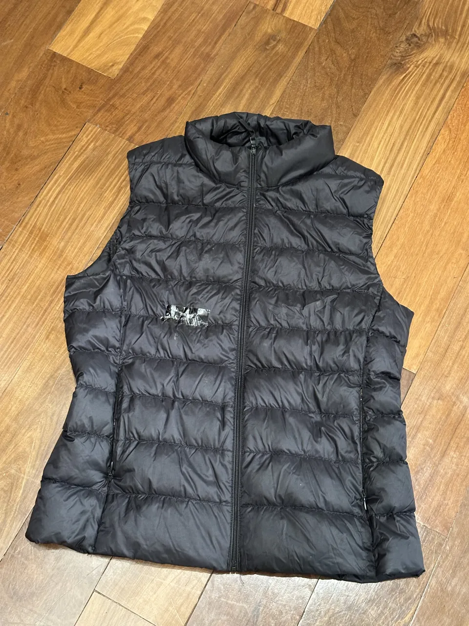 Chaleco acolchado negro con cuello alto y cierre central. Adelante esta roto, se ve pegado con cinta. puede servir para usar debajo de otra campera. Tiene dos bolsillos laterales con cierre.