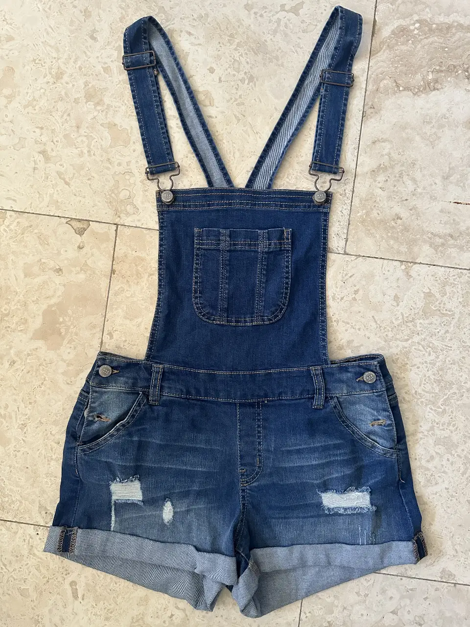 ¡Dale un toque canchero a tu look con estos jardineritos! Perfectos para un estilo casual y relajado, ideales para el verano. Tienen detalles de roturas y dobladillos deshilachados que le dan un toque moderno. ¡Compralos ahora y lucí un look único!