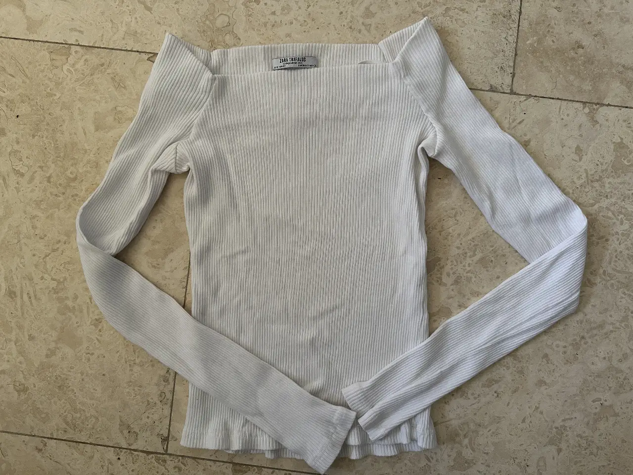 Remera manga larga blanca de Zara Trafaluc, con  hombros al descubrierto y tejido acanalado. Ideal para un look casual y moderno.