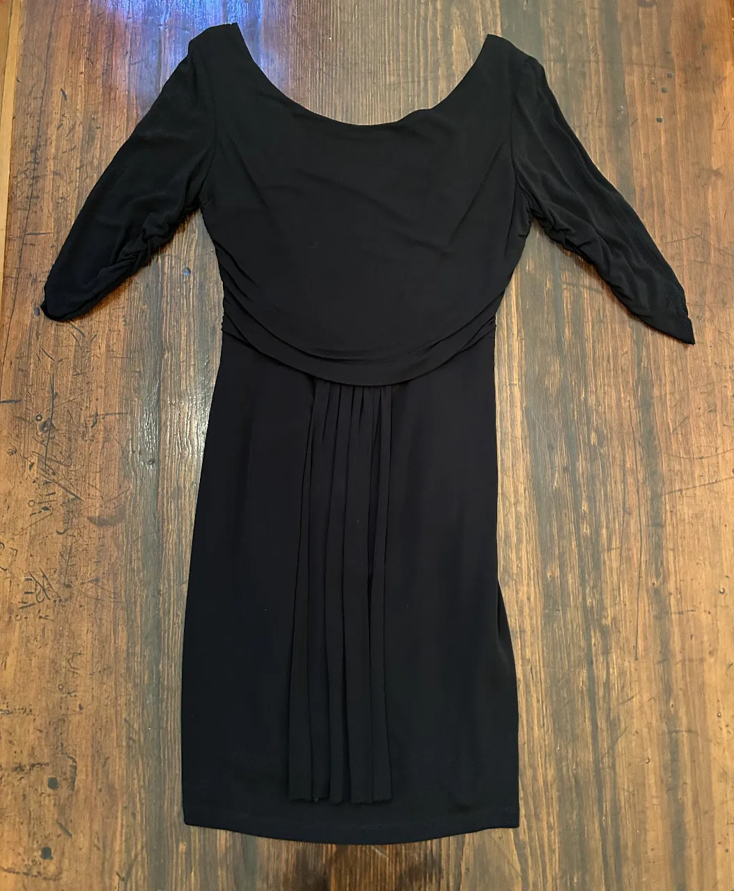 Vestido negro corto, ideal para fiesta o salida. Diseño elegante con mangas 3/4 y detalle fruncido en la cintura. Cierre en la espalda.