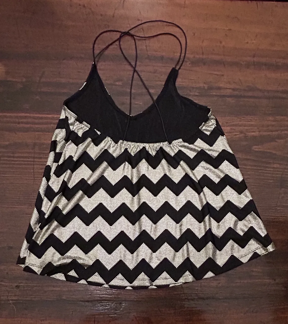 Musculosa de mujer con estampado de chevron en negro y dorado. Diseño con tirantes finos y espalda descubierta. Ideal para fiestas y salidas.