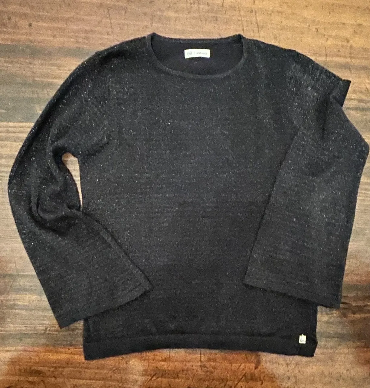 Sweater negro con mangas amplias y detalles brillantes. Ideal para un look moderno y cómodo.