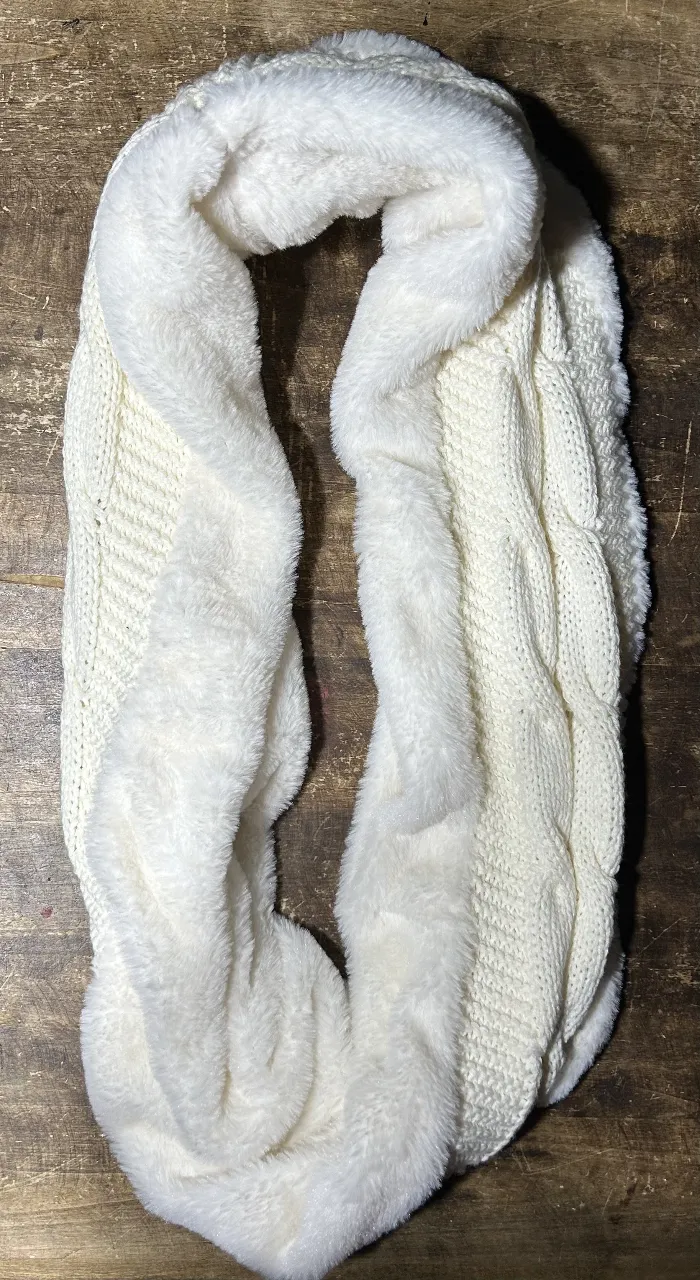 Bufanda circular de tejido de punto en color blanco con detalle de piel sintética en los bordes. Ideal para abrigarte con estilo en invierno.