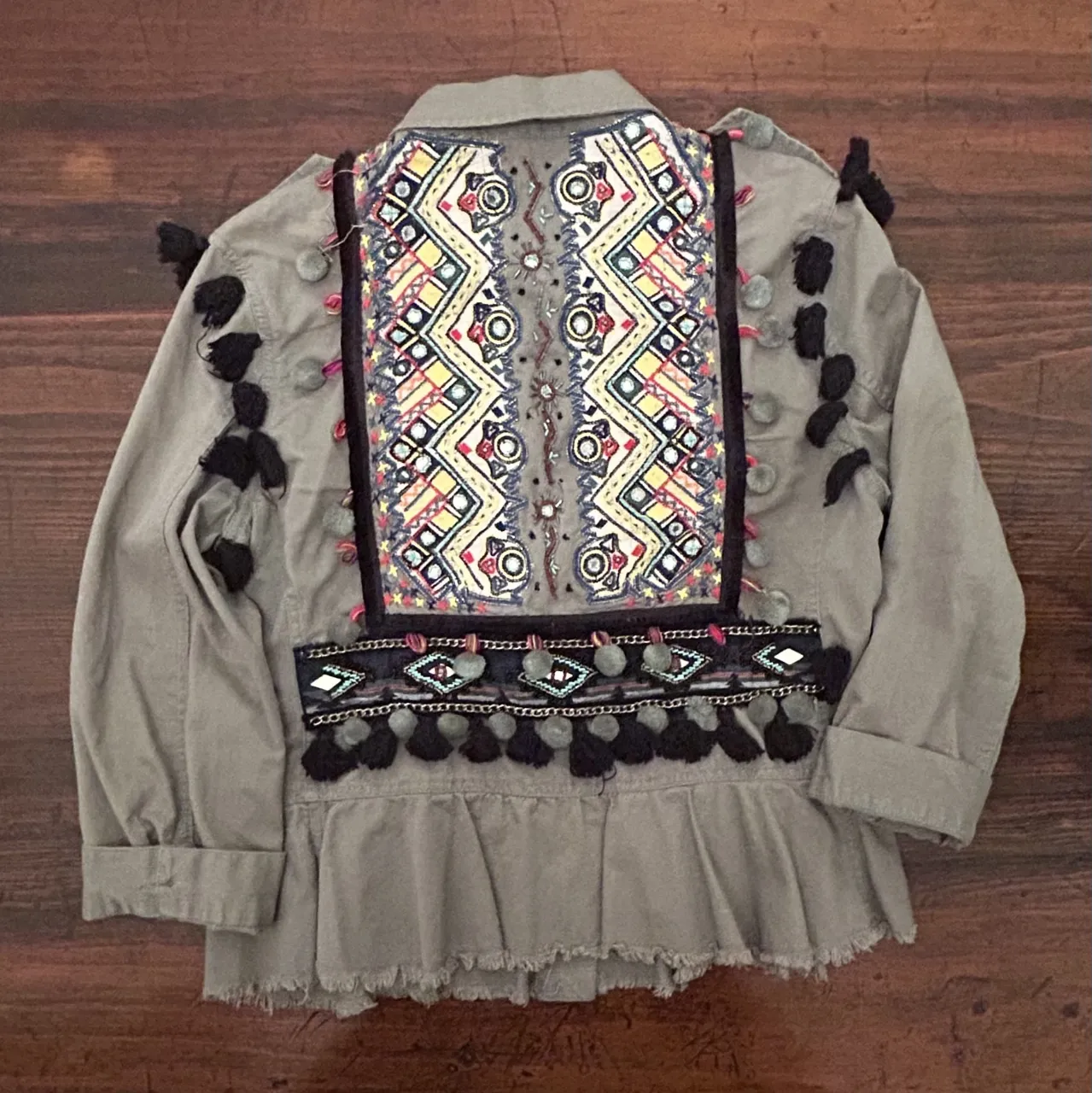 Campera estilo bomber de mujer, con detalles bordados en la espalda y flecos en la parte inferior. Ideal para un look boho chic.