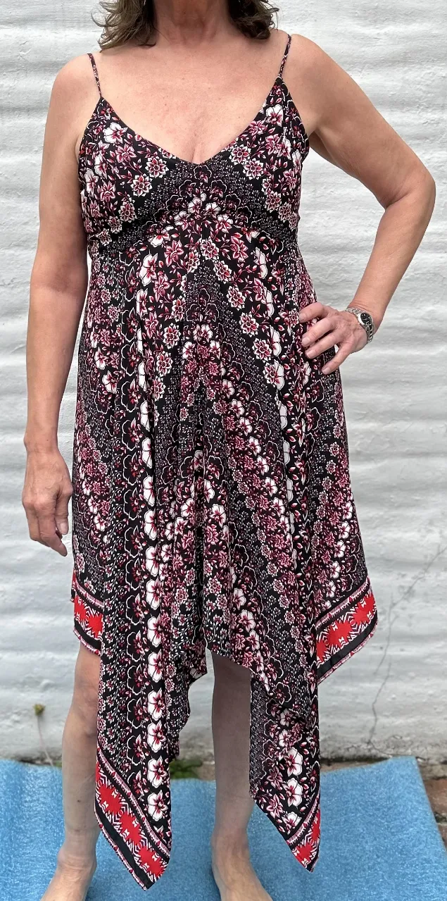 Vestido estampado con breteles finos y escote en V. Diseño asimétrico con volados y detalles en rojo y blanco. Ideal para un look fresco y canchero.