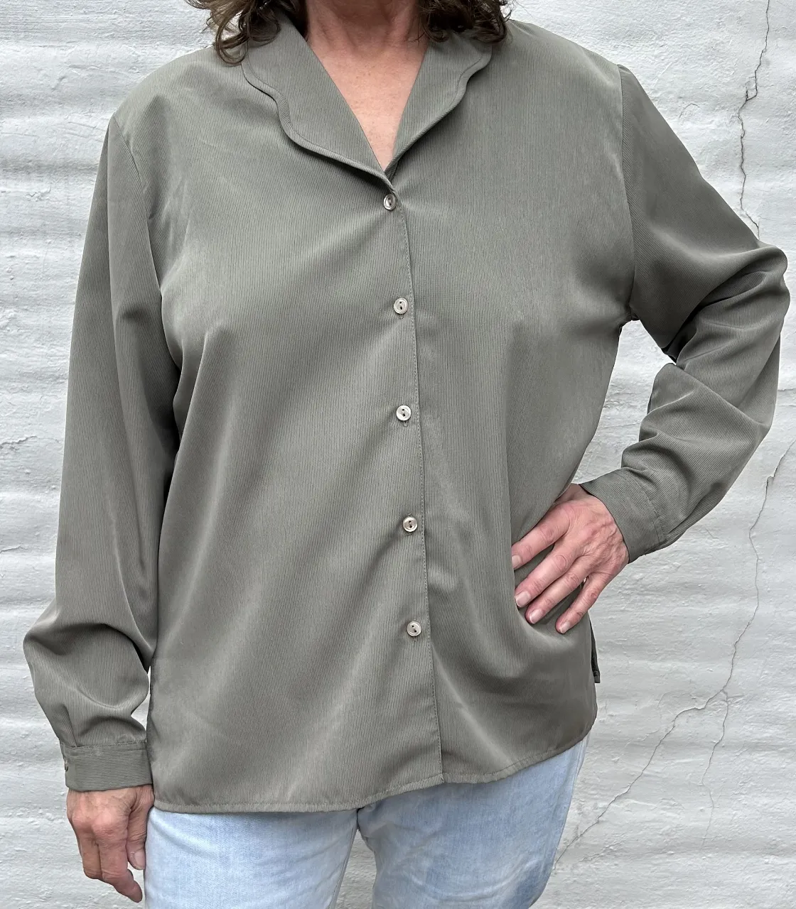 Camisa de manga larga en color verde musgo, con un diseño liso y rayas muy finiras en la tela que le dan textura. Posee cuello camisero y se abotona al frente. Perfecta para un look casual o para ir a la oficina.