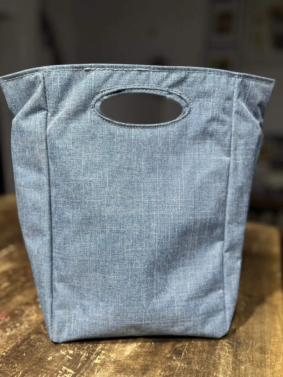 Bolso tipo lunchera de tela denim azul. Ideal para llevar el almuerzo al trabajo o a la escuela. Cuenta con un asa superior y cierre. Interior térmico. Medidas base rectángulo de 20x13 cm Alto 30cm
