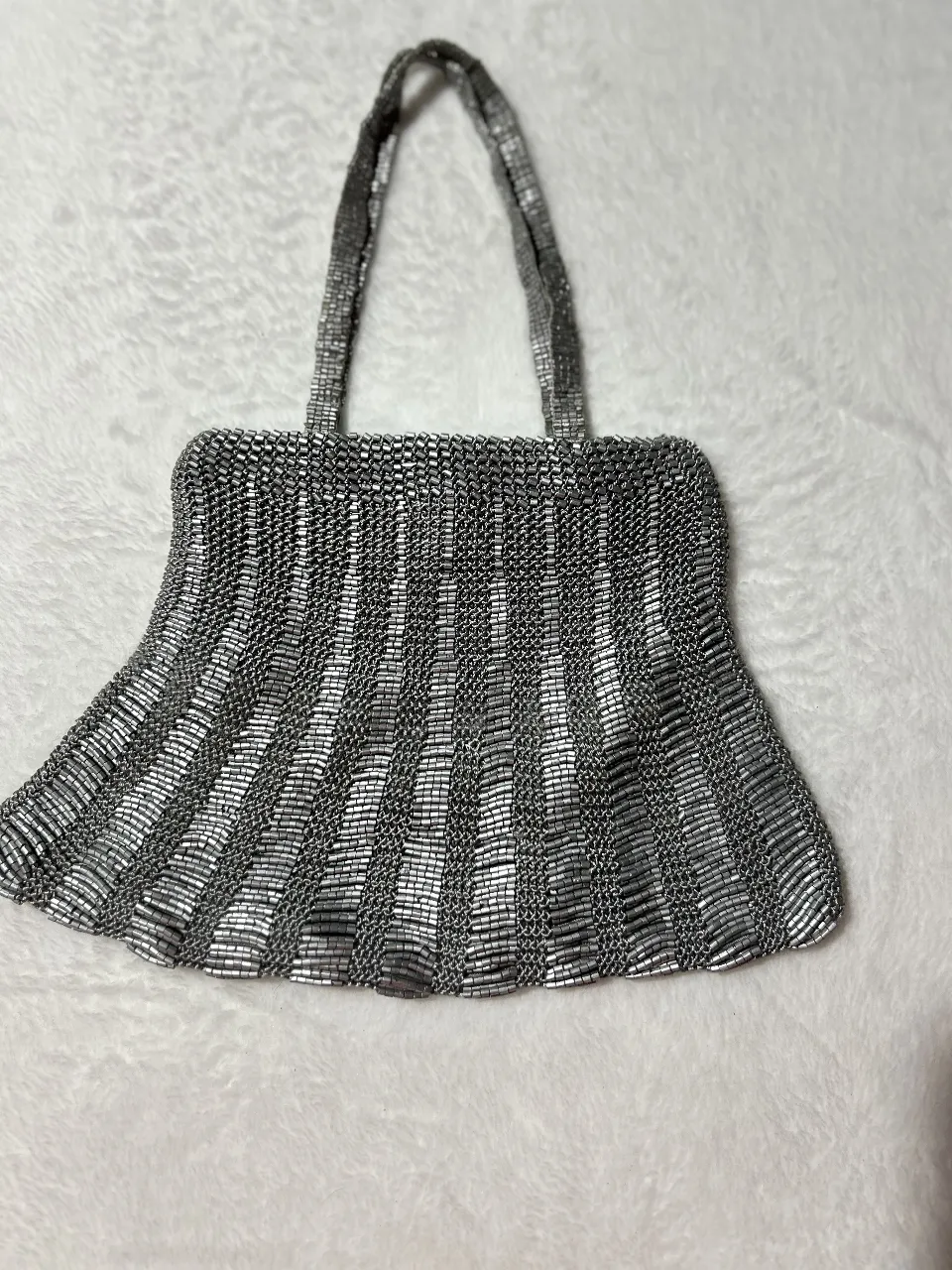 Mini cartera de mano plateada con diseño de cuentas y canutillos. Hecha en India. Ideal para eventos especiales.