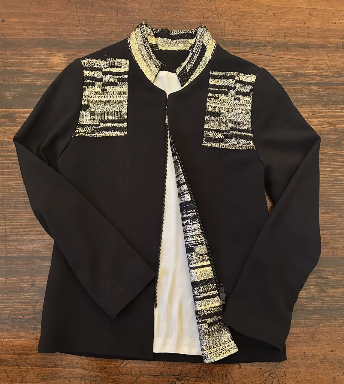 Chaqueta uruguaya negra con detalles dorados en solapas y hombros. Ideal para un look elegante y sofisticado.