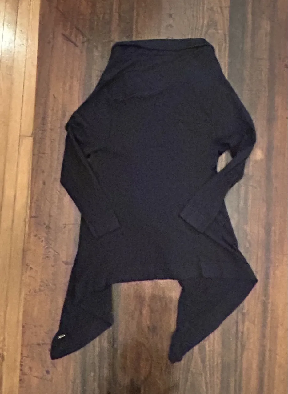 Cardigan negro de mujer, con diseño asimétrico y mangas largas. Ideal para un look casual y moderno.