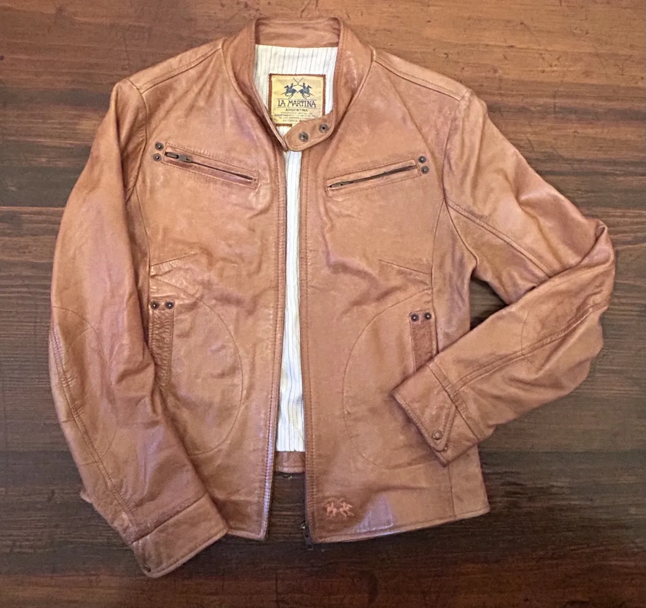 Chaqueta de cuero marrón estilo biker para mujer. Diseño clásico con detalles de costura y cierre frontal. Ideal para un look casual y moderno.