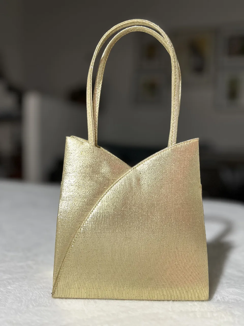 Cartera dorada con manijas cortas. Pisee manija larga. Ideal para eventos formales o fiestas.