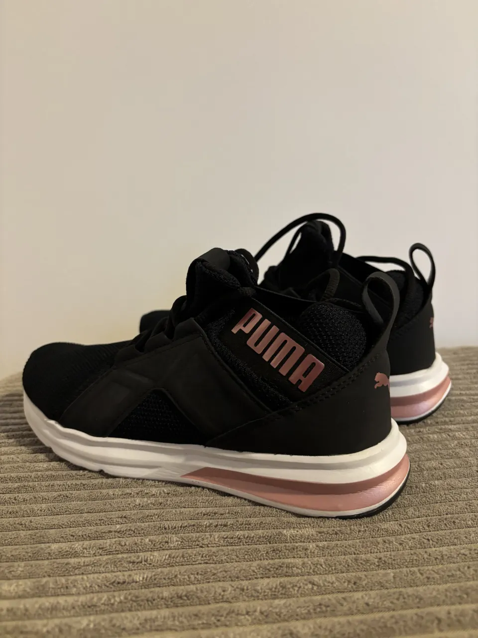 Zapatillas deportivas Puma Softride Enzo Nxt negras con detalles en rosa metalizado. Ideales para entrenar o caminar. 