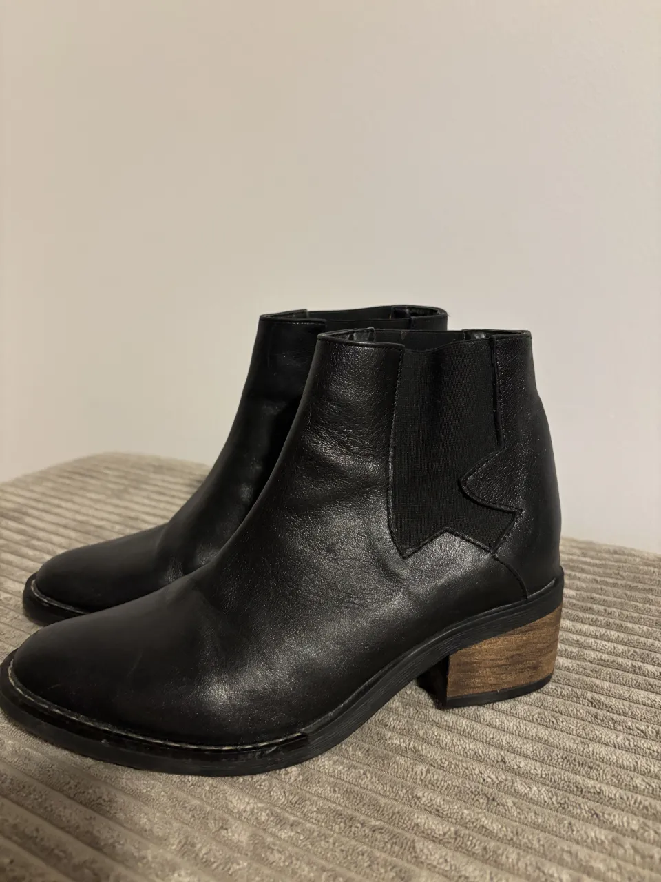 Botitas de cuero negras. Tienen un diseño moderno con elástico a los costados y un taco de madera que le da un toque canchero. 