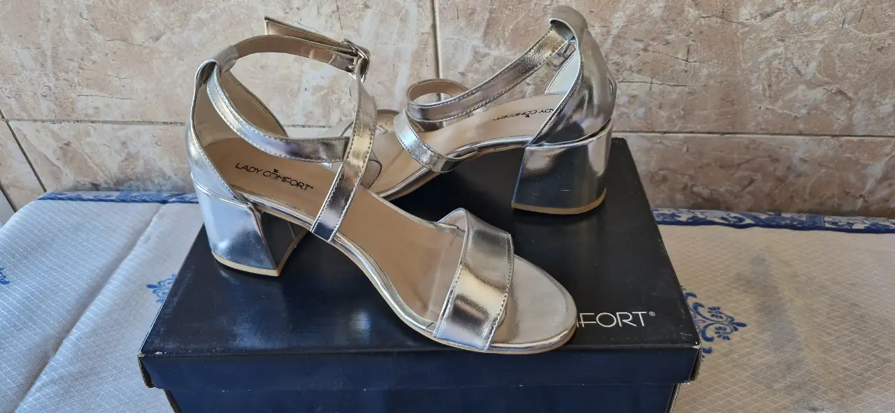 Sandalias de mujer plateadas con taco cuadrado y pulsera en el tobillo. Marca Lady Comfort.
